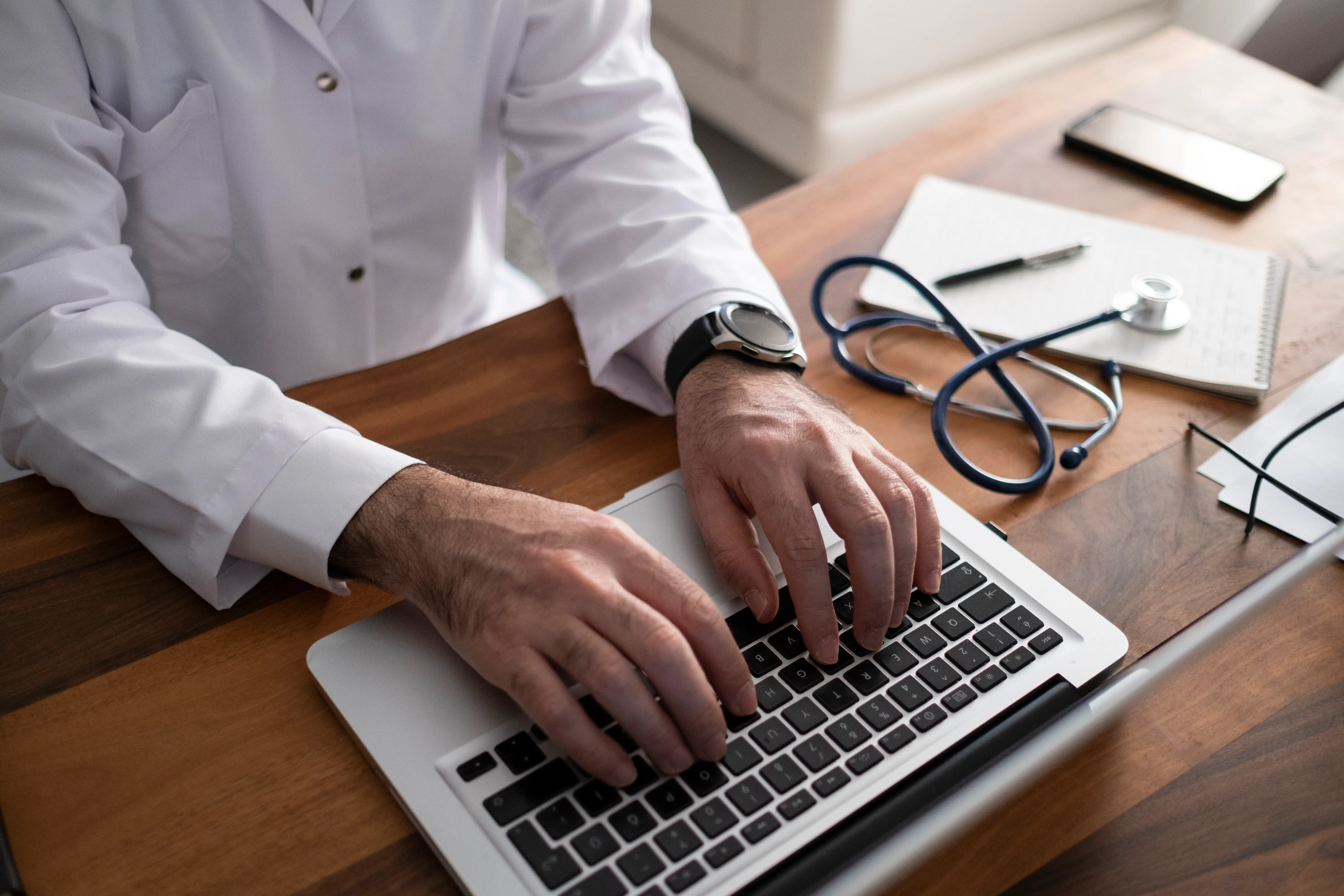 A doctor typing in a laptop