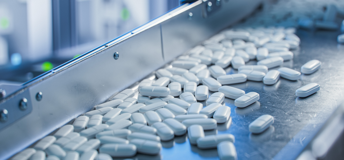 White pills on a chute in a manufacturing facility