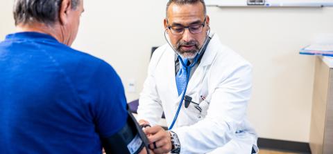 A doctor checking a patient with a stethoscope.